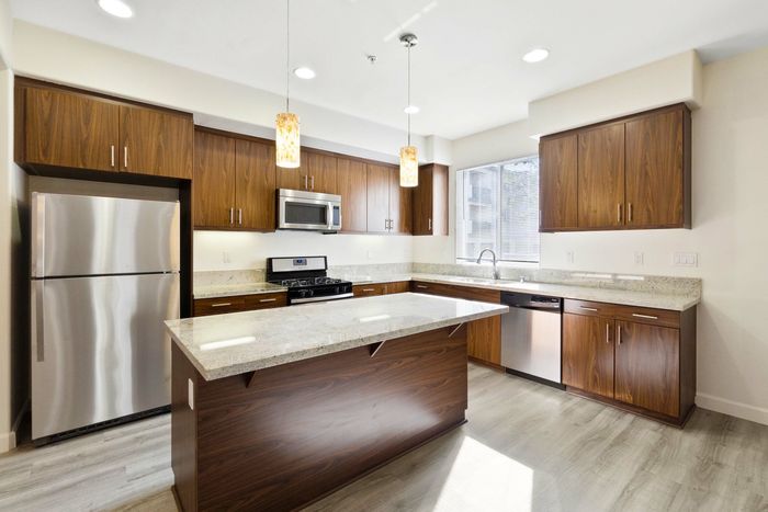 open kitchen with granite countertops and a kitchen island and stainless steel appliances