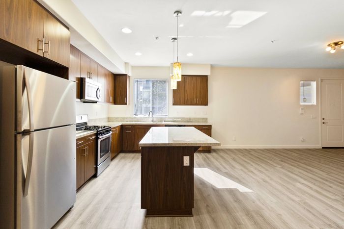 open kitchen with granite countertops and a kitchen island and stainless steel appliances