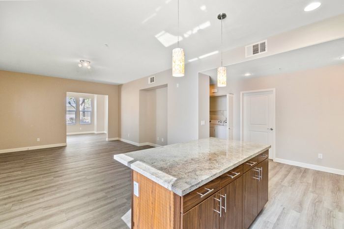 open kitchen with granite countertops and a kitchen island and stainless steel appliances and living room