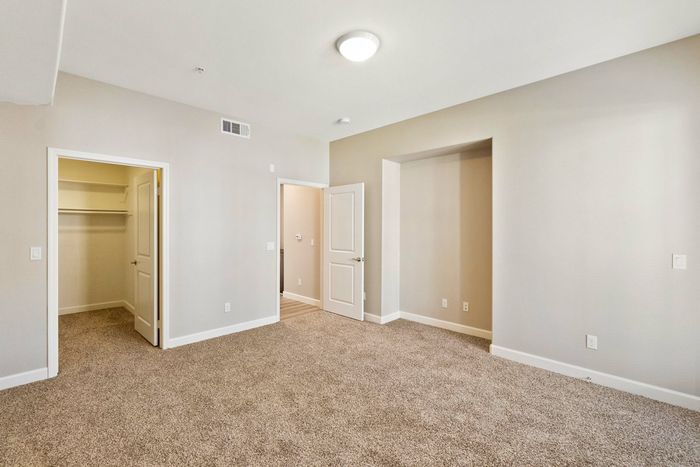 bedroom with beige carpeting and entry to the large closet
