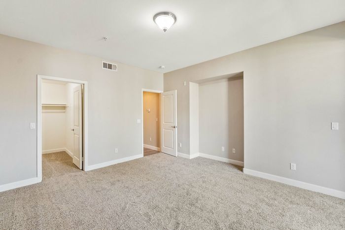 bedroom with beige carpeting and entry to the large closet