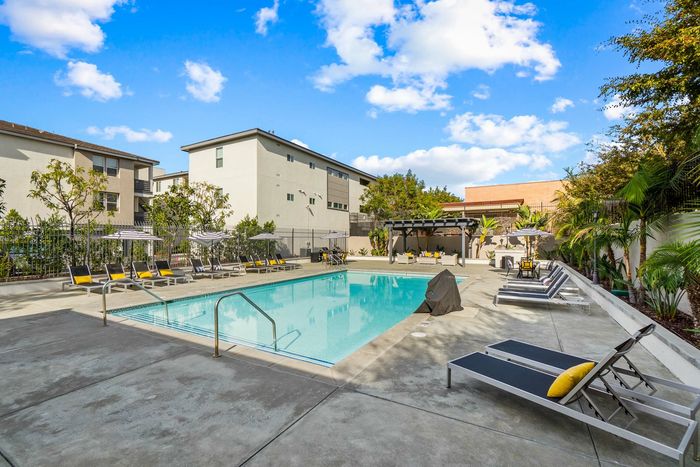 swimming pool and lounge chairs and umbrellas surrounding