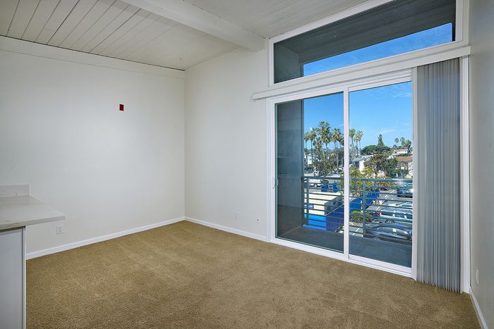 Living room with balcony and plush capreting