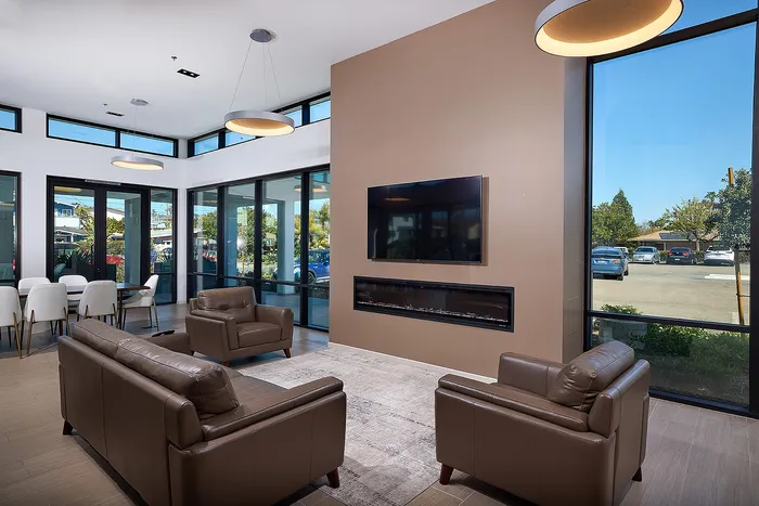 Updated Resident lounge area with fireplace, TVs, and seating
