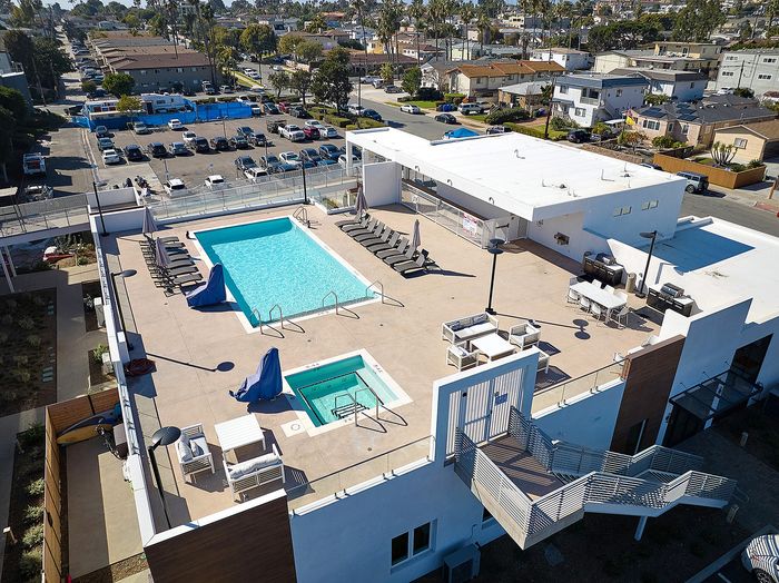 Renovated pool, lounge and spa area on rooftop deck with expansive views