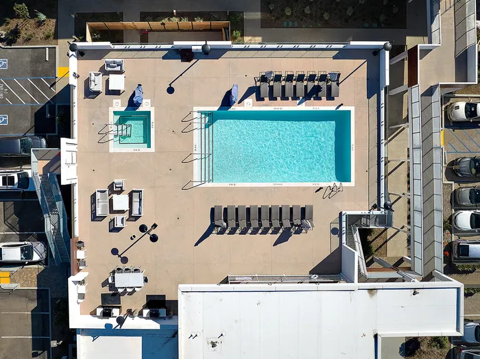 Renovated pool, lounge and spa area on rooftop deck with expansive views