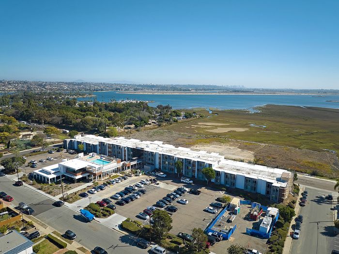 Aerial view of renovated pool, lounge and spa area on rooftop deck with expansive views