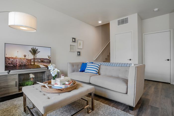 living room with taupe sofas, decorative rug and glass coffee table at Grapevine Villa