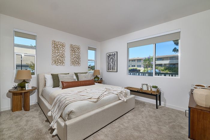 Large carpeted bedroom with large windows at Dezi Apartments in Serra Mesa, San Diego