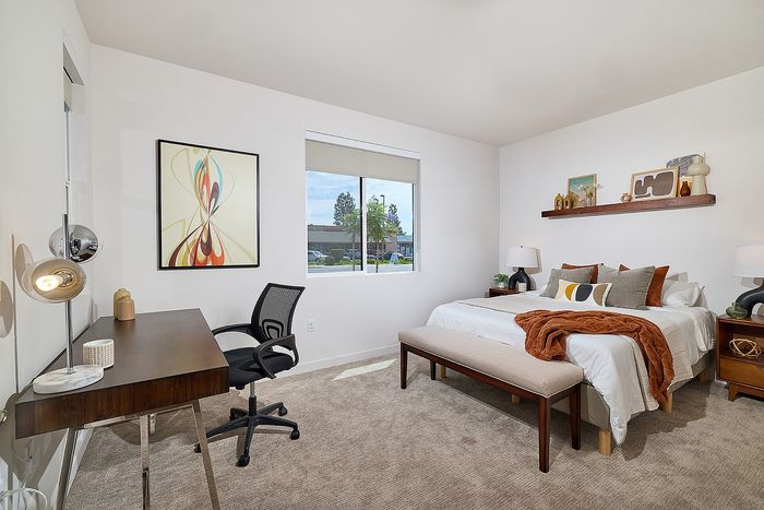 Large carpeted bedroom with large windows at Dezi Apartments in Serra Mesa, San Diego
