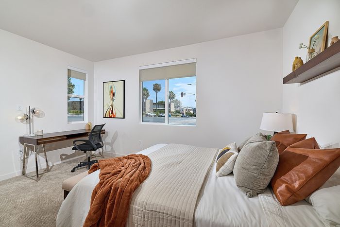 Spacious carpeted bedroom with large windows at Dezi Apartments in Serra Mesa, San Diego