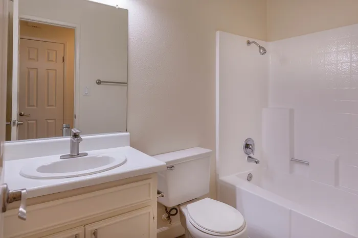 Updated bathroom with a large sink vanity and bright, upgraded lighting.