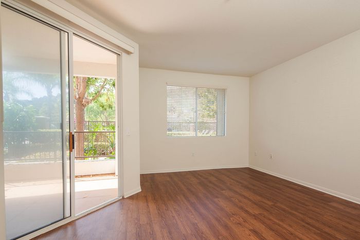 Clean and modern living space featuring a large sliding glass door that provides access to a private patio.
