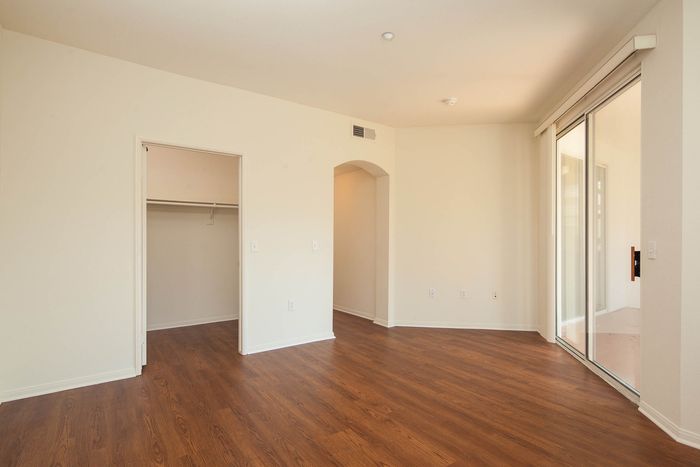 Open-concept living area with wood-style flooring and large sliding glass doors leading to an outdoor space.