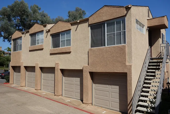 Exterior view of a community building featuring a row of attached garages available for residents.