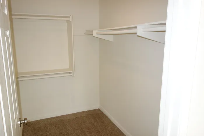 Interior view of a walk-in closet with built-in shelving and ample storage space.