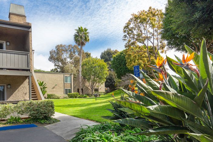 Beautifully manicured community grounds with vibrant flowers and views of the apartment buildings.