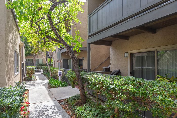 Scenic view of the apartment building exterior surrounded by lush landscaping and green shrubbery.