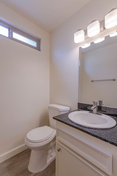 Vertical view of a bathroom vanity area featuring a large mirror and bright vanity lighting.