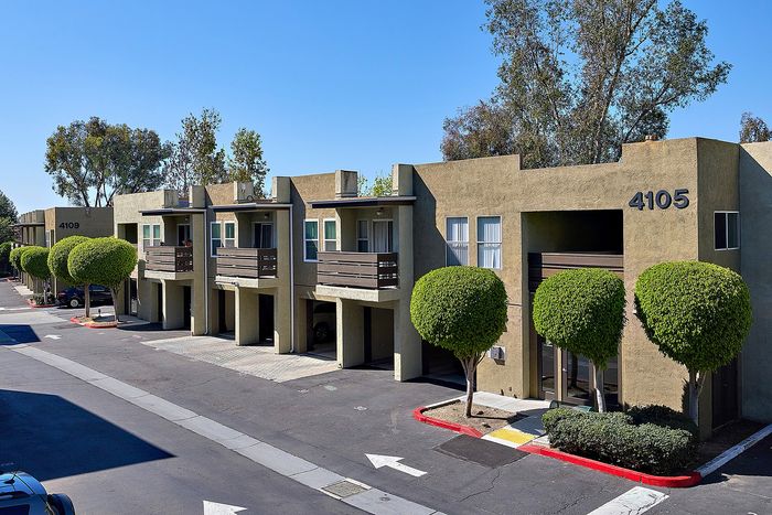 Main office with parking lot and apartments with trees and blue sky