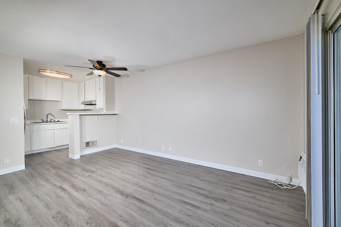 Kitchen and living space with wooden floors and ceiling fan
