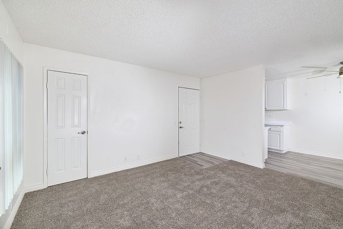 Living room at a unit at Pine Vista with carpet and white paint