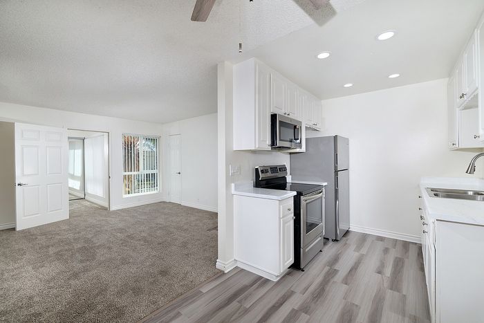 Kitchen at a unit at Pine Vista with carpet and white paint and lvp in the kitchen