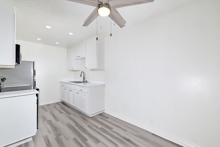 Another view of the 2 bedroom kitchen at Pine Vista with white cabinets, lvp flooring