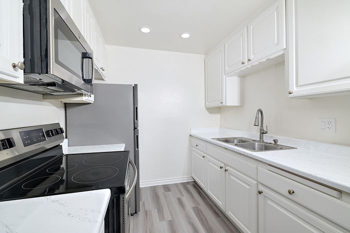 Closeup of the kitchen at pine vista with white cabinets, stainless appliances