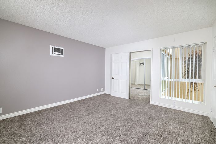 Living room at PIne Vista with a light purple wall and carpet and a large window