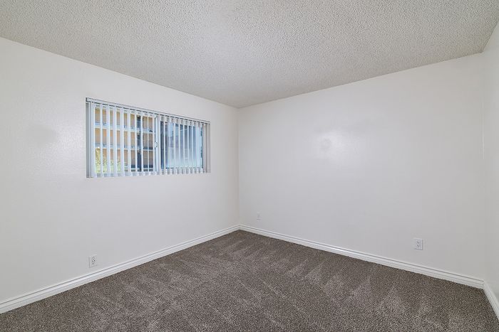 Bedroom 2 in the 2 bedroom floorplan at Pine Vista with carpet, and a window