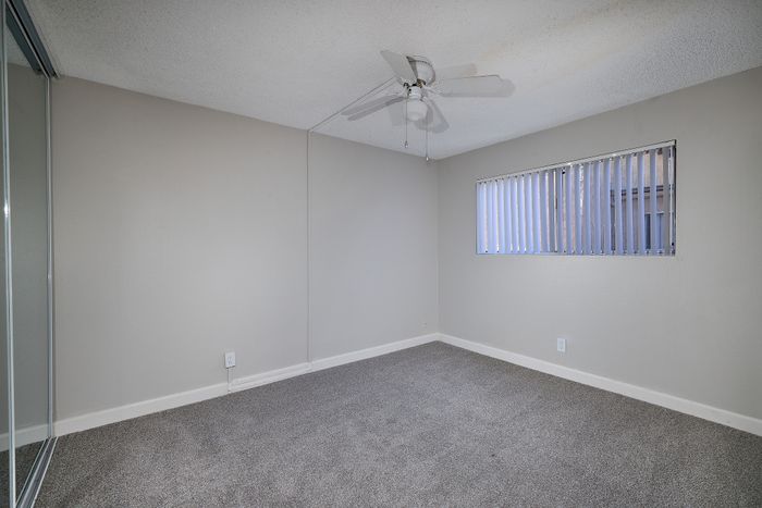 bedroom with ceiling fan and carpet and window