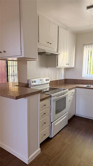 Kitchen at Vogue Manor with a stove and white cabinets