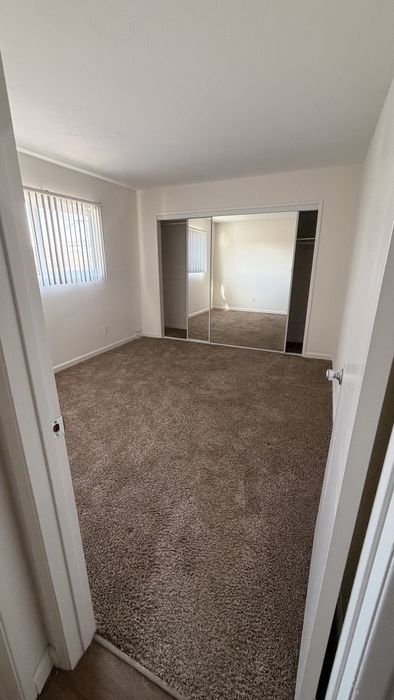 Bedroom at vigue Manor with mirrored closet doors and carpet