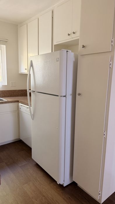 Kitchen at Vogue Manor with white cabinets and white fridge