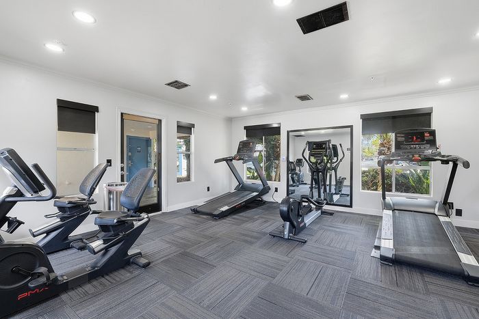Fitness center with equipment and mirror.