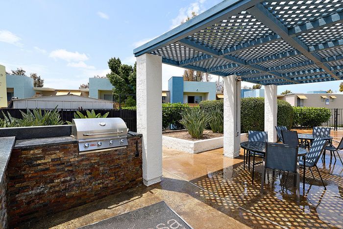 Community area with seating, BBQ, and greenery.