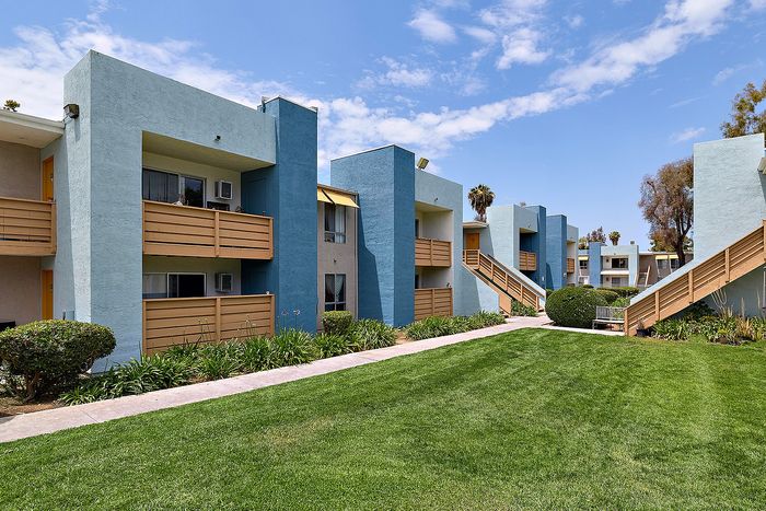Apartments with stairs and grass.