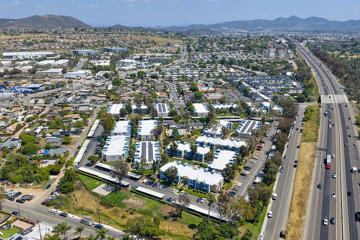 Aerial establishing shot with surrounding roads, nearby neighborhoods, landmarks, and the horizon.