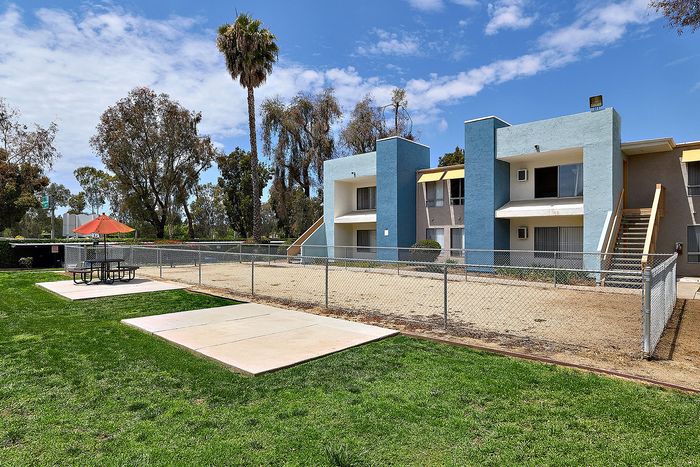 Dog park with seating and apartment units.