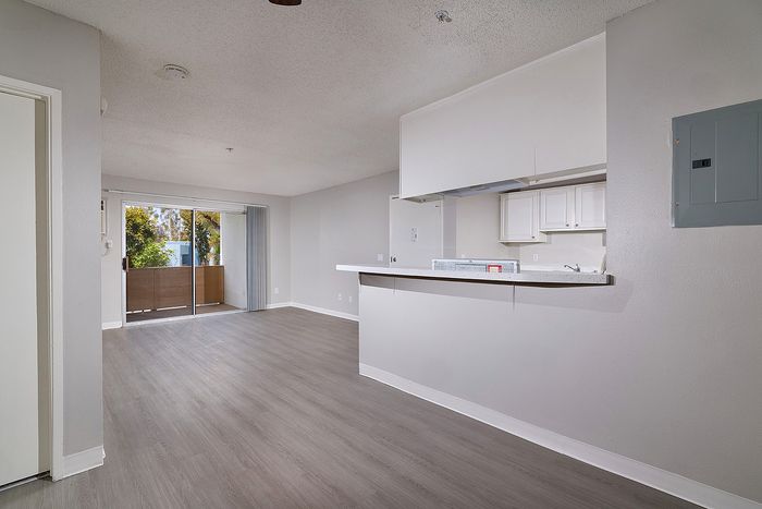 Kitchen and open living space with wooden floor and patio.