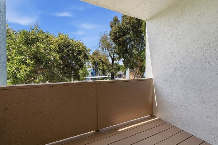 Balcony with trees and blue sky.