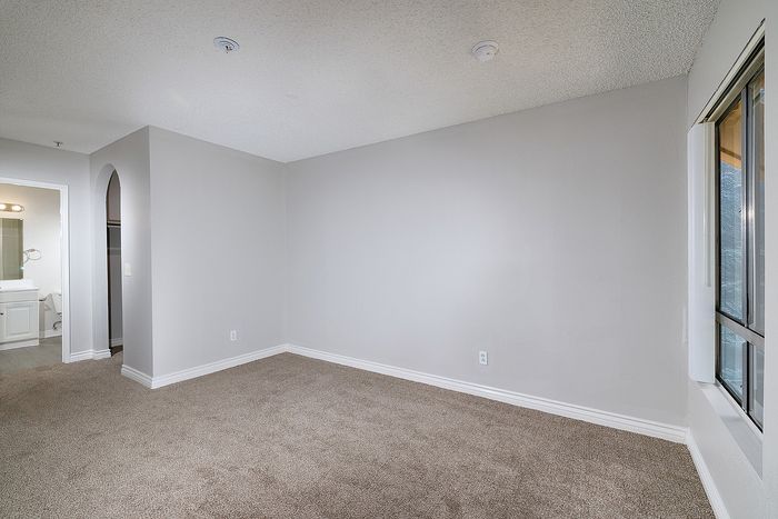 Living area with window and carpet.