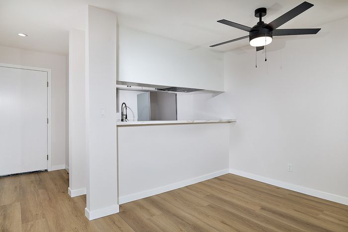 View into the Kitchen and dining area with a ceiling fan and bar seating area