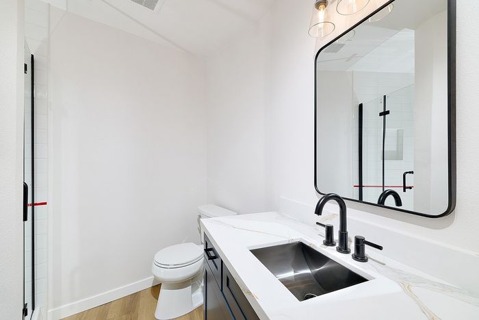 Bathroom in unit 28 at Melrose Canyon with navy cabinets, quartz countertops and black accents