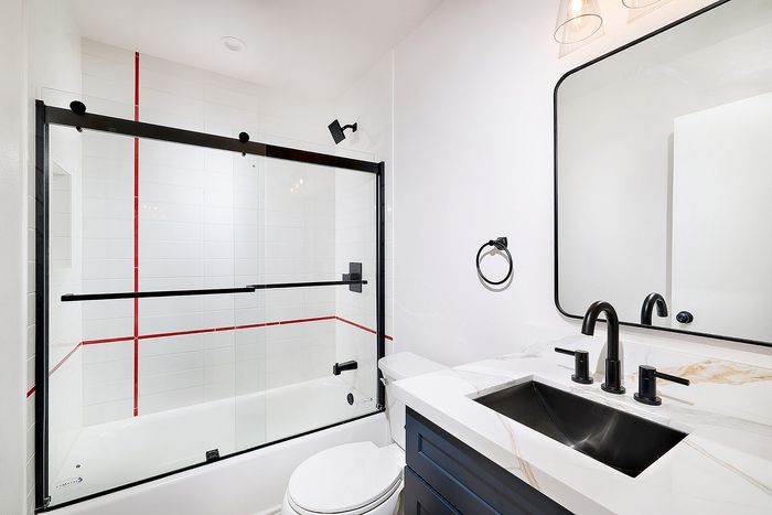 Bathroom in unit 28 at Melrose Canyon with navy cabinets, quartz countertops and black accents