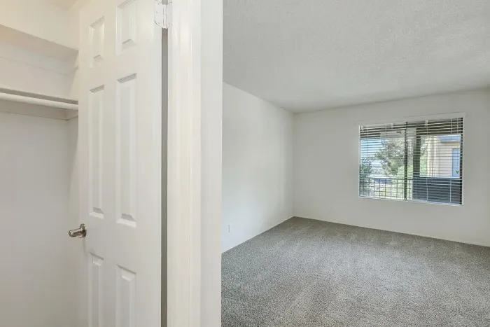 Bright bedroom with large window and carpet at Elan - Scripps Terrace.