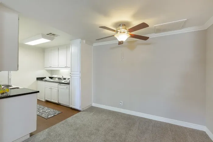 Modern kitchen with white cabinets and fan at Elan - Scripps Terrace.