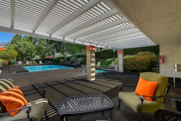 Shaded poolside lounge area with patio seating at Elan - Terraza La Jolla