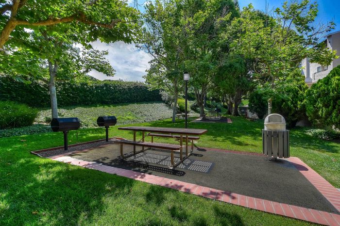 Outdoor BBQ and picnic area under mature trees at Elan - Terraza La Jolla